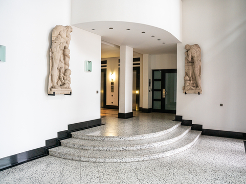 Das helle Foyer mit Steinfußboden und Wandschmuck im Erdgeschoss der SHD Geschäftsstelle in Leipzig lädt zum Eintreten ein.