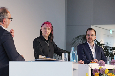 Drei Personen diskutieren auf einer Bühne über IT-Lösungen im Kontext von SHD.