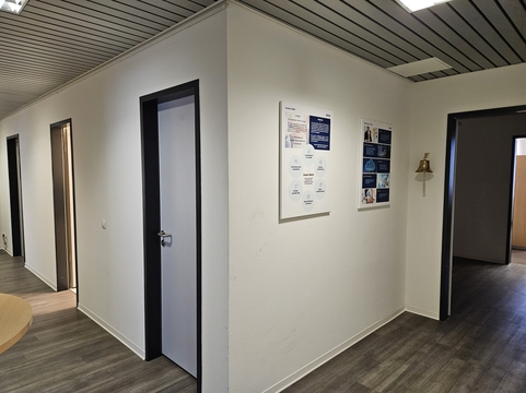 Ein Büroflur mit Türen, Informationsplakaten von SHD und modernem Design in der Hamburger Geschäftsstelle.