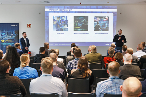 SHD präsentiert eine Sicherheitskonferenz, während Experten über Cyberangriffe und Schutzstrategien referieren.