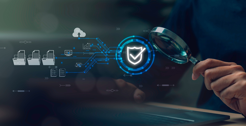 Eine Hand mit einer großen Lupe untersucht einen Prozess. Dieser wird durch verschiedene Symbole dargestellt und endet in einem Schutzschild mit positivem Haken, der Erfolg ausdrückt.