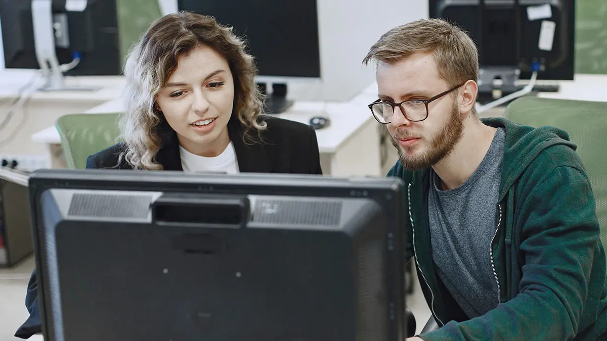 Zwei junge Menschen vor dem PC