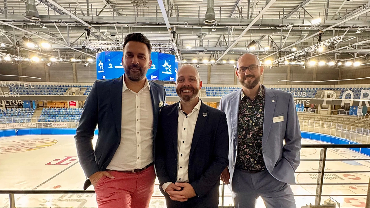 Fröhliches Gruppenbild vom Geschäftsführer der Dresdner Eislöwen sowie einem Geschäftsführer und Account Manager von SHD innerhalb der Joynext Arena.