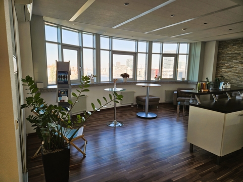 Modernes Büro von SHD in Berlin mit Tischen, Pflanzen und großer Fensterfront für Beleuchtung.