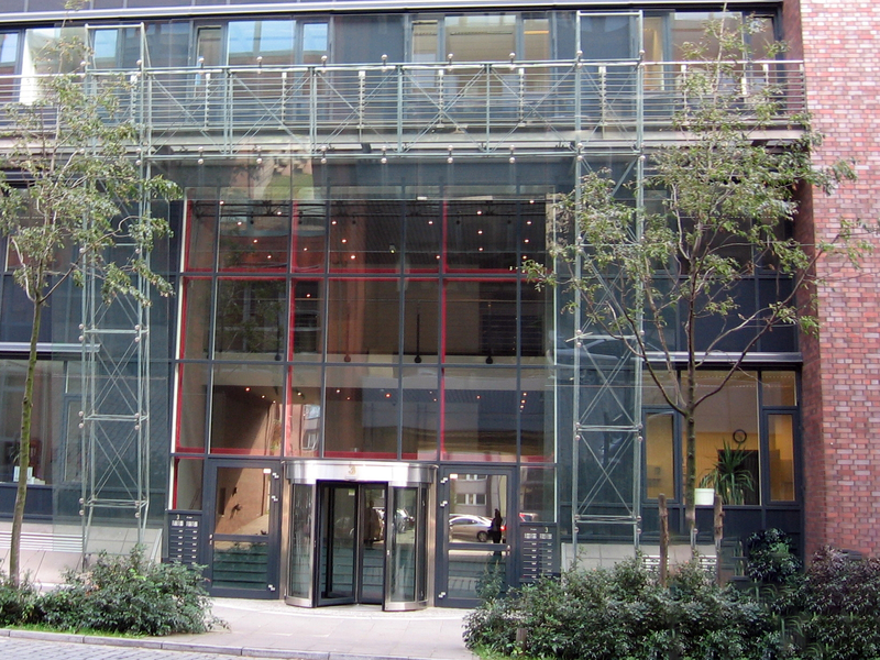 Modernes Gebäude mit gläserner Fassade, Eingangstür und Umgebung, geeignet für IT-Services wie bei SHD.