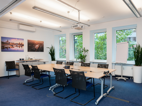 Moderne Konferenzräume mit einem großen Tisch und technischem Equipment unterstützen SHD bei Präsentationen.