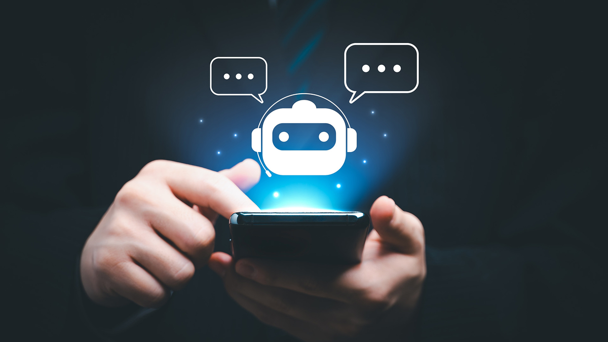 Eine Hand tippt auf einem Smartphone, während ein virtueller Assistent kommuniziert. SHD bietet innovative IT-Lösungen.