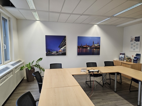 Moderne Büroräume von SHD, ausgestattet mit Besprechungstisch, Pflanzen und informativen Wandbildern.