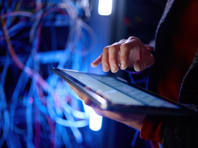 Ein Benutzer steuert ein Tablet zur Netzwerküberwachung im IT-Umfeld von SHD.