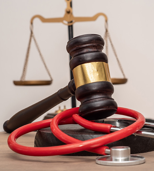 Ein Stethoskop ist um einen Richterhammer gewickelt und symbolisiert neue Gesetze und Rechtsprechung im KRITIS-Sektor.