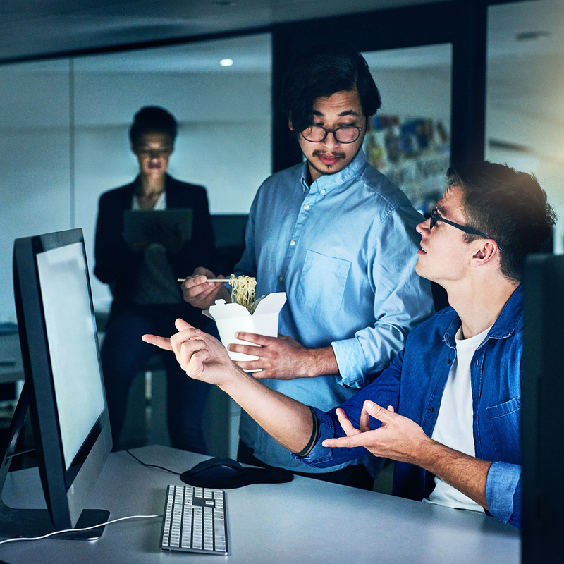 Zwei Mitarbeiter des Security Operations Center diskutieren im Büro über einen IT-Sicherheitsvorfall.