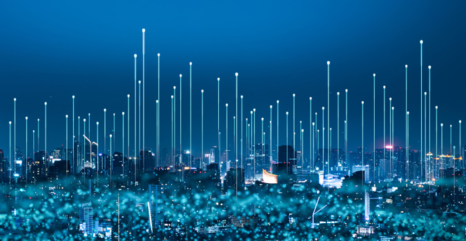 Helle Lichtstrahlen steigen über einer städtischen Skyline in der Nacht auf.