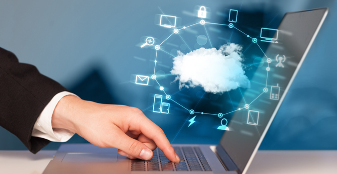 Eine Hand tippt auf einem Laptop, um mit einer Cloud-basierten Benutzeroberfläche zu interagieren.